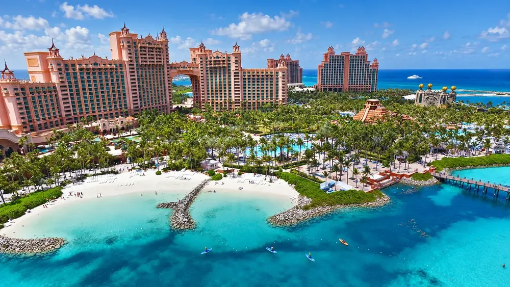The Atlantis resort towers on Paradise Island above a lagoon, a white sand beach and a jetty in clear turquoise water