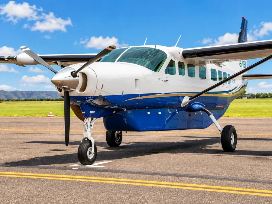 A blue and white Cessna Grand Caravan EX on the apron